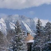 Snowy trees and mountains frame the top of a campus building